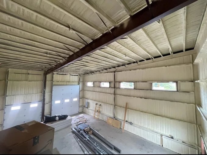 Empty metal garage interior with corrugated walls and dark ceiling beam
